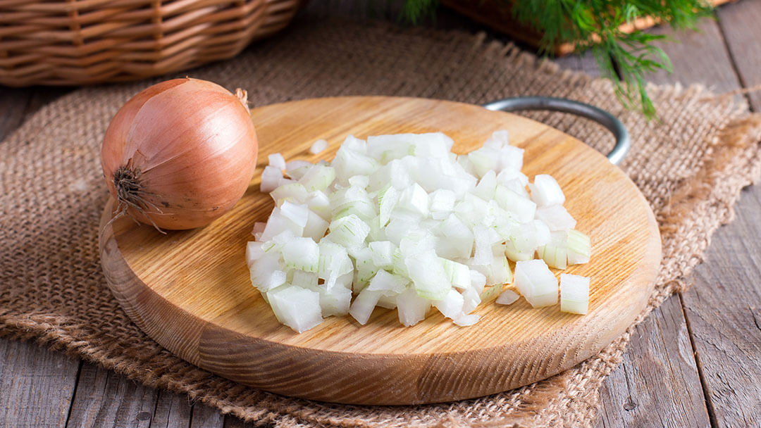 Raw onion, chopped very small cubes on a wooden board