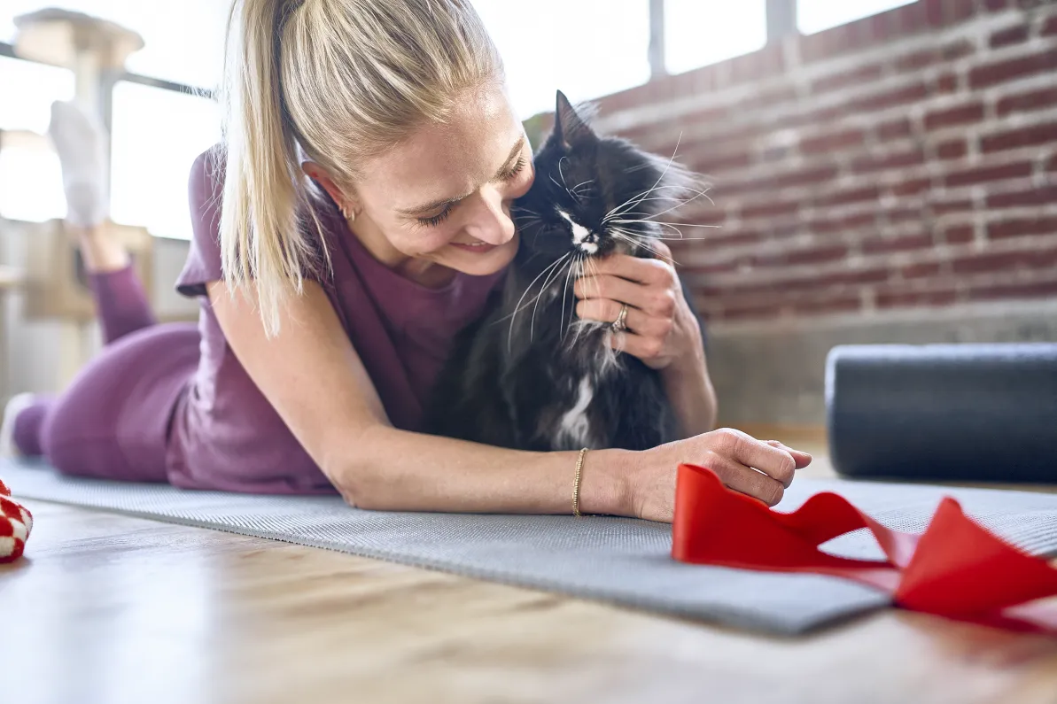 Woman exercising with her black and white cat