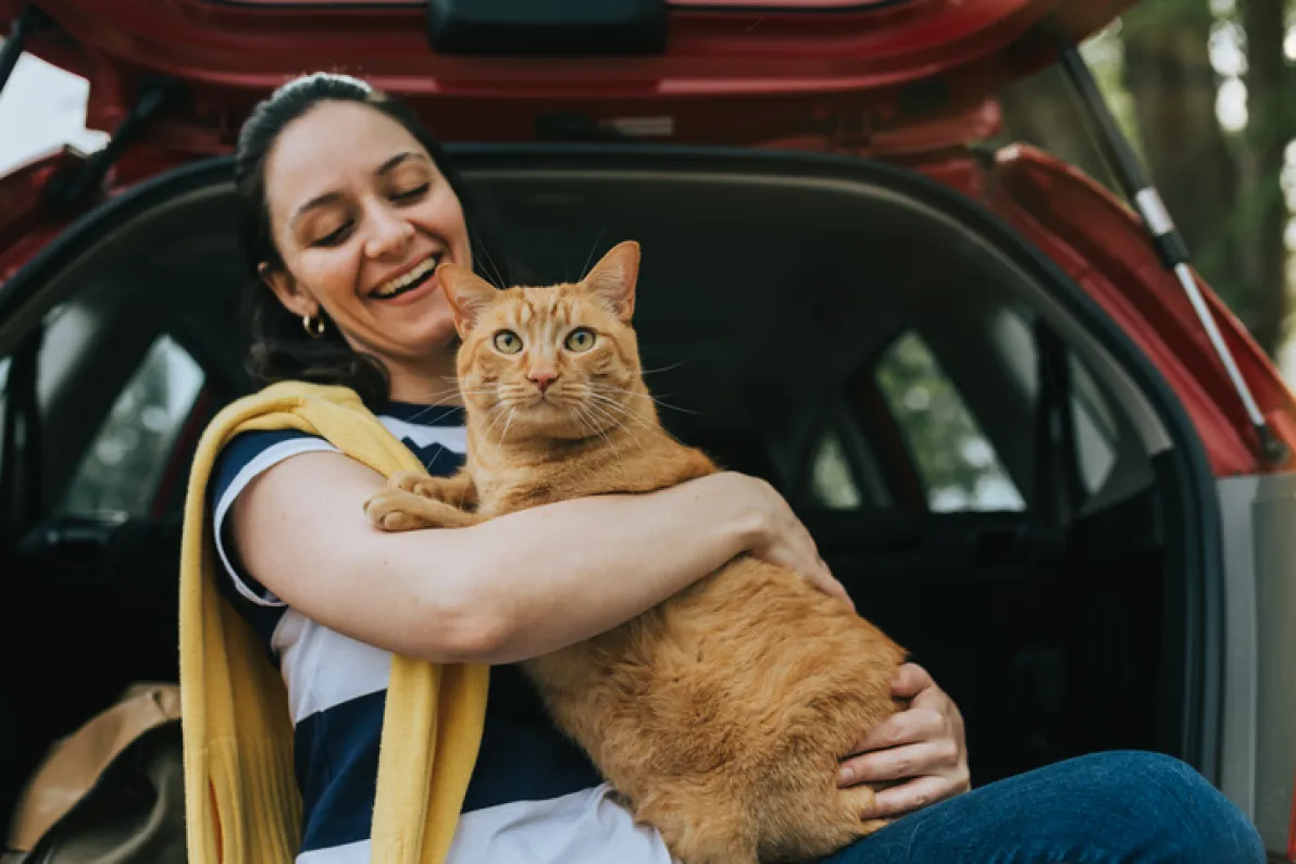 Woman holding cat in car