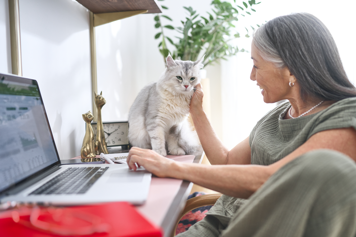 Woman in her office with her white and grey cat